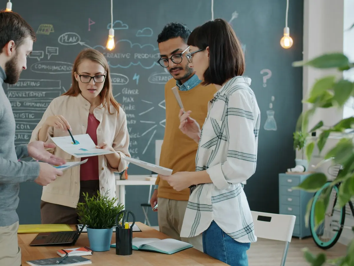 A creative software team reviewing product plans together in a studio office